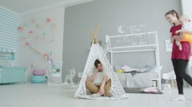 Baba bebek kulübesinde otururken telefonda konuşuyor