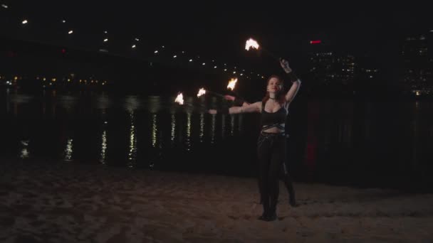 Hübsche Feuerwerkskörper jonglieren nachts mit brennenden Fackeln — Stockvideo