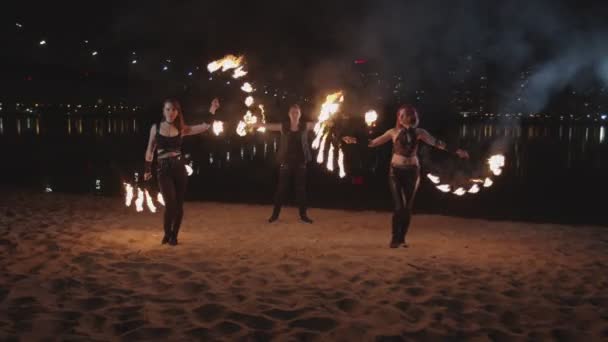 Jóvenes artistas de fireshow haciendo malabarismos con llamas cerca del río — Vídeos de Stock