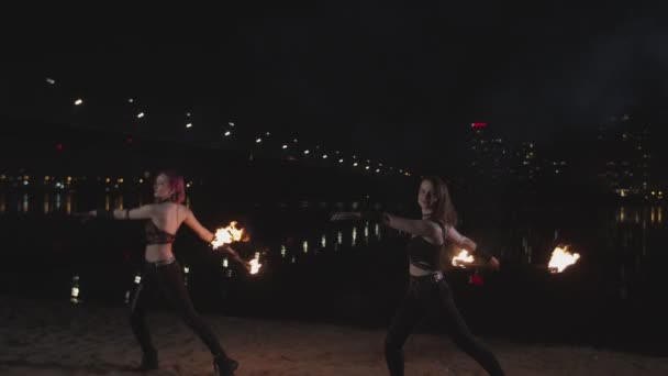 Aantrekkelijke firegirls dansen met staven 's nachts — Stockvideo