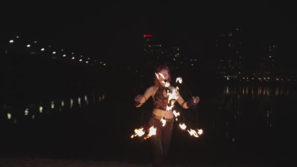 Női művész létrehozása tűz körök spinning rajongók — Stock videók
