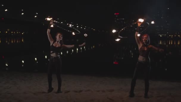 Jonge vrouwen draaien vuur hula hoepels boven hoofd — Stockvideo