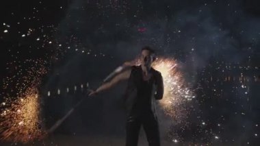 Nehirde havai fişek leri döndürme sanatını gösteren sanatçı