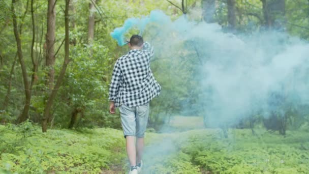 Hombre con bomba de humo caminando por el bosque de verano — Vídeos de Stock