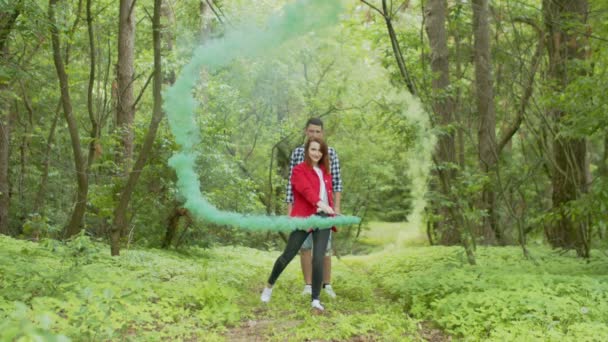 Young woman dancing with smoking torches in forest — ストック動画