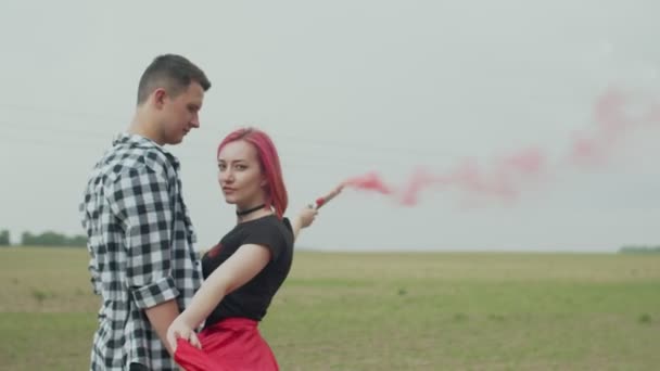 Positive couple with color smoke bomb posing in nature — Stock Video