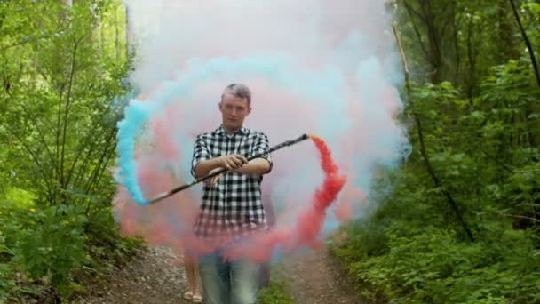 Ember, aki színes füstkört hoz létre az erdők között — Stock videók