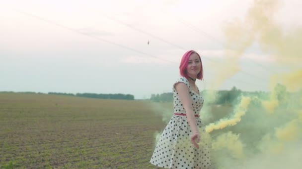 Jolie femme marchant dans la fumée de couleur à travers le champ — Video
