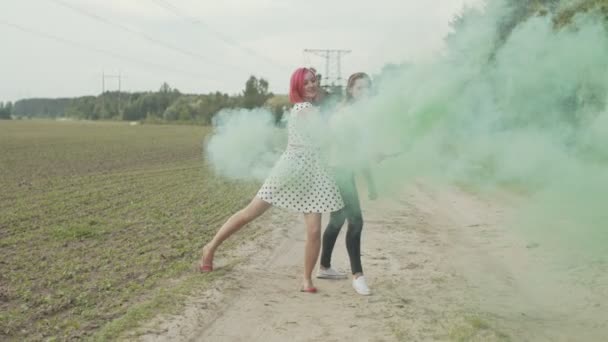 Mujeres con bombas de humo de colores relajándose en la naturaleza — Vídeos de Stock
