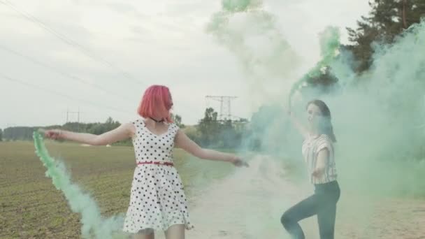Mujeres felices con bombas de humo saltando al aire libre — Vídeos de Stock