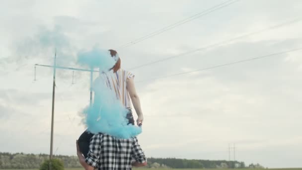 Женщина с дымовой бомбой сидит на плечах мужчин — стоковое видео