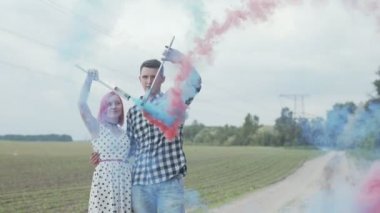 Genç çift doğada dumanlı kalp oluşturuyor.