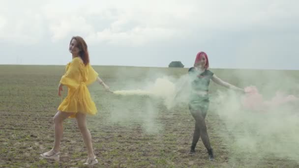 Mujeres girando en las nubes de humo de colores al aire libre — Vídeos de Stock