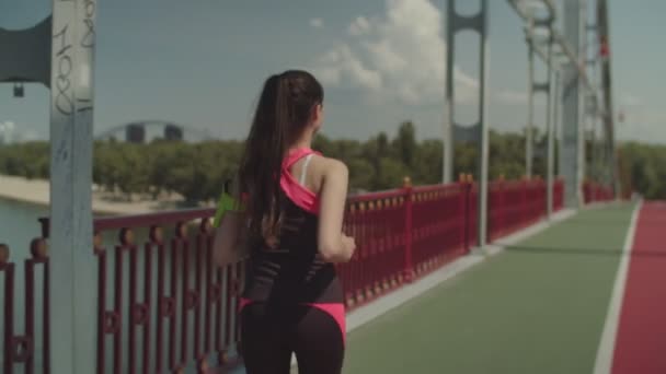 Fitness vrouw joggen op brug in de ochtend — Stockvideo