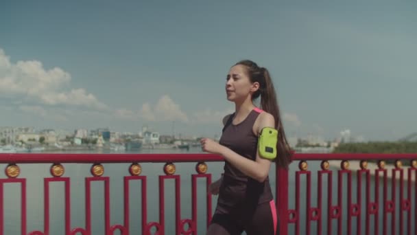 Deportiva mujer caminando rápido en el puente después de correr — Vídeos de Stock