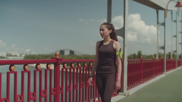 Sporty female jogging and doing push ups on bridge — Stock Video