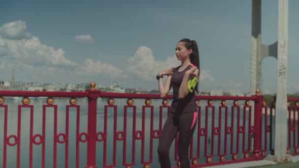 Женщина разогревает мышцы во время тренировки в городе — стоковое видео