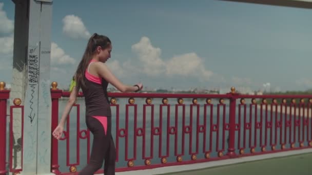 Спортивная бегунья расслабляется после тренировки в городе — стоковое видео