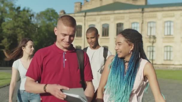 Разнообразные студенты, идущие по университетскому кампусу — стоковое видео