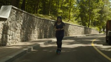 Mutlu kadın yokuş aşağı hızda paten sürme