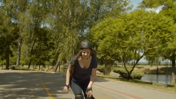 Активная молодая женщина катается на роликах на скорости в парке — стоковое видео