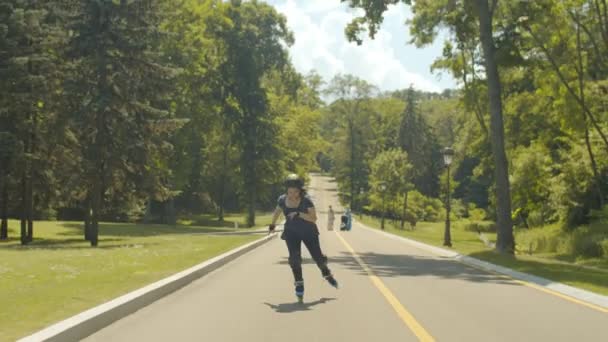 Opgewonden jonge vrouw roller rijden op en neer Hill — Stockvideo