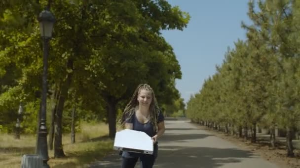 Жіночий ролик, що працює в парку доставки піци — стокове відео