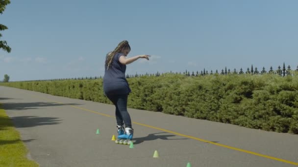 Vrouwelijke roller inline skating achteruit in Park — Stockvideo