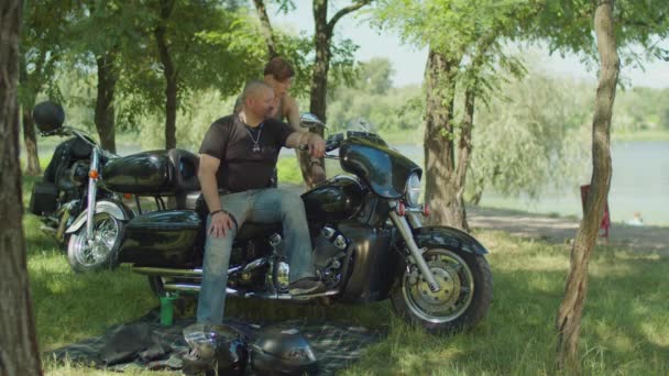 Casal de motociclistas discutindo moto na natureza — Vídeo de Stock