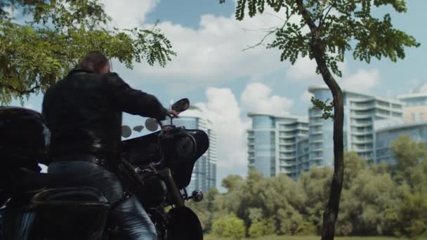 Silhouette de motard appréciant le paysage urbain après la promenade — Video