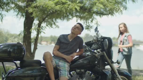 Молодая пара наслаждается отдыхом на мотоцикле в парке — стоковое видео