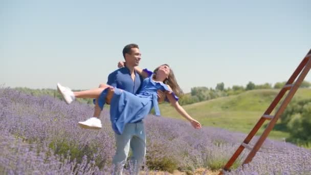 Многорасовая пара веселится на лавандовом поле — стоковое видео
