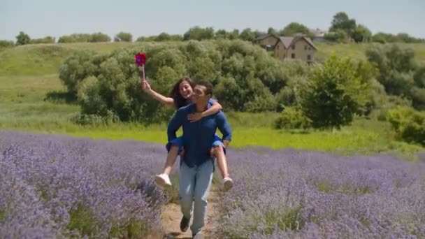 Vrolijke man geeft piggyback Ride naar vrouw buiten — Stockvideo