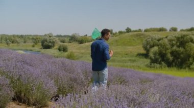 Neşeli adam alanında net ile kelebekler yakalamak
