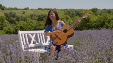 Doğada gitar çalan pozitif gülümseyen kadın