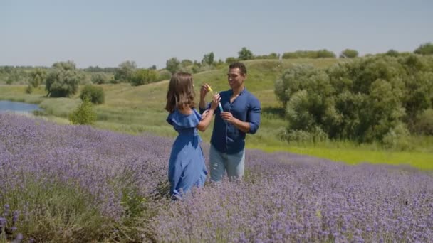 Opgewonden gemengd race paar spelen met zeepbellen — Stockvideo