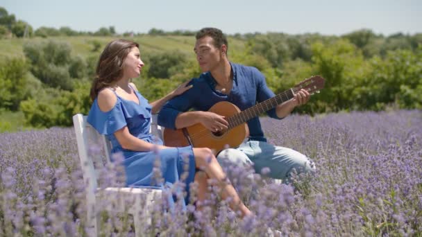 Романтичный мужчина поет серенаду женщине с гитарой на открытом воздухе — стоковое видео