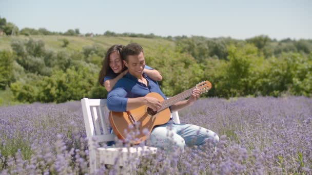 Casal multirracial tocar guitarra serenata ootdoors — Vídeo de Stock