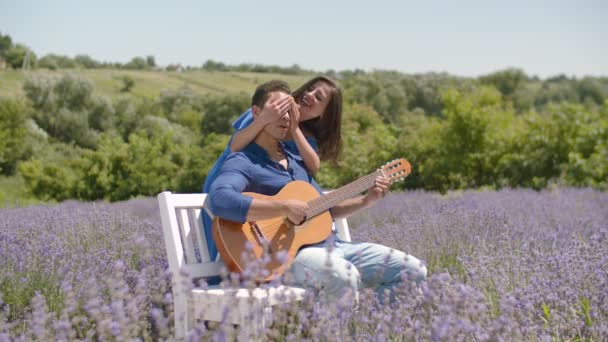 Πολυεθνικό ζευγάρι με κιθάρα χαλάρωσης στη φύση — Αρχείο Βίντεο