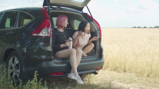 Несчастная женщина испытывает отвращение к горячему напитку в багажнике машины — стоковое видео