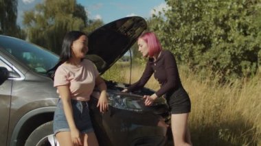 Kafası karışmış kadın parçalanmış araba motorubakıyor