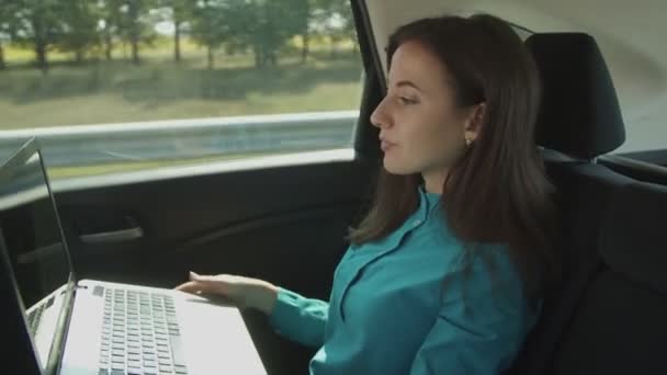 Femme d'affaires avec ordinateur portable faisant appel vidéo dans la voiture — Video
