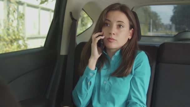 Seriöse Frau plaudert mit Handy im Auto — Stockvideo