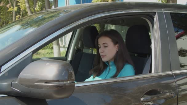 Precioso conductor femenino se abrocha el cinturón de seguridad en el coche — Vídeo de stock