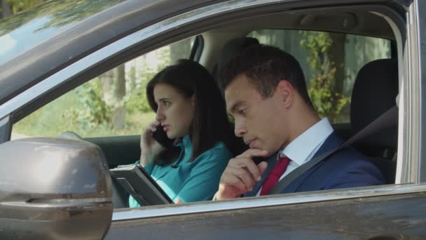 Casal de negócios multiétnicos trabalha em conjunto no carro — Vídeo de Stock