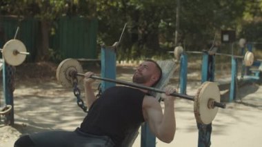 Fit adam barbell eğimli tezgah basın açık havada yapıyor