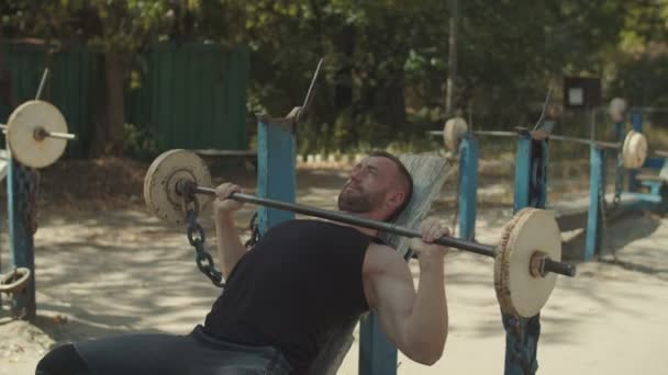 Fit homme faisant barre inclinaison banc presse à l'extérieur — Video