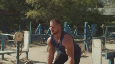 Bodybuilder açık spor salonunda deadlift egzersiz yapıyor