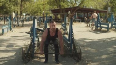 Vücut geliştirmeci halter egzersiz açık havada yapıyor