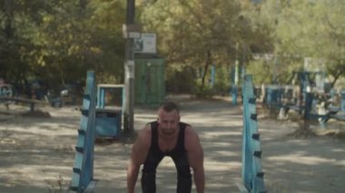 Bodybuilder powerlifting eğitim açık havada yapıyor